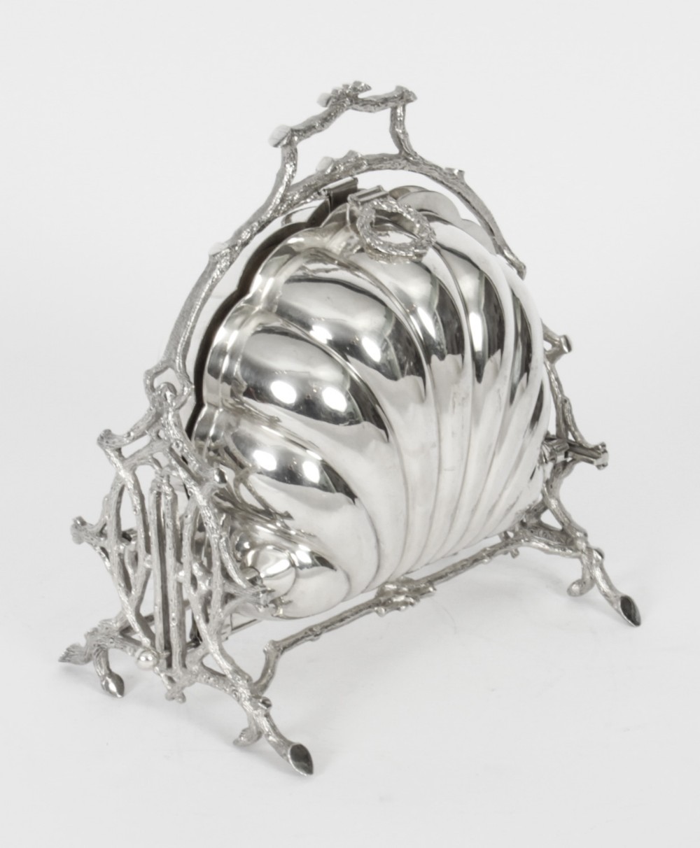 A Victorian silver-plated folding biscuit box in the shape of a clam shell, supported by a cast branch-like metal frame.