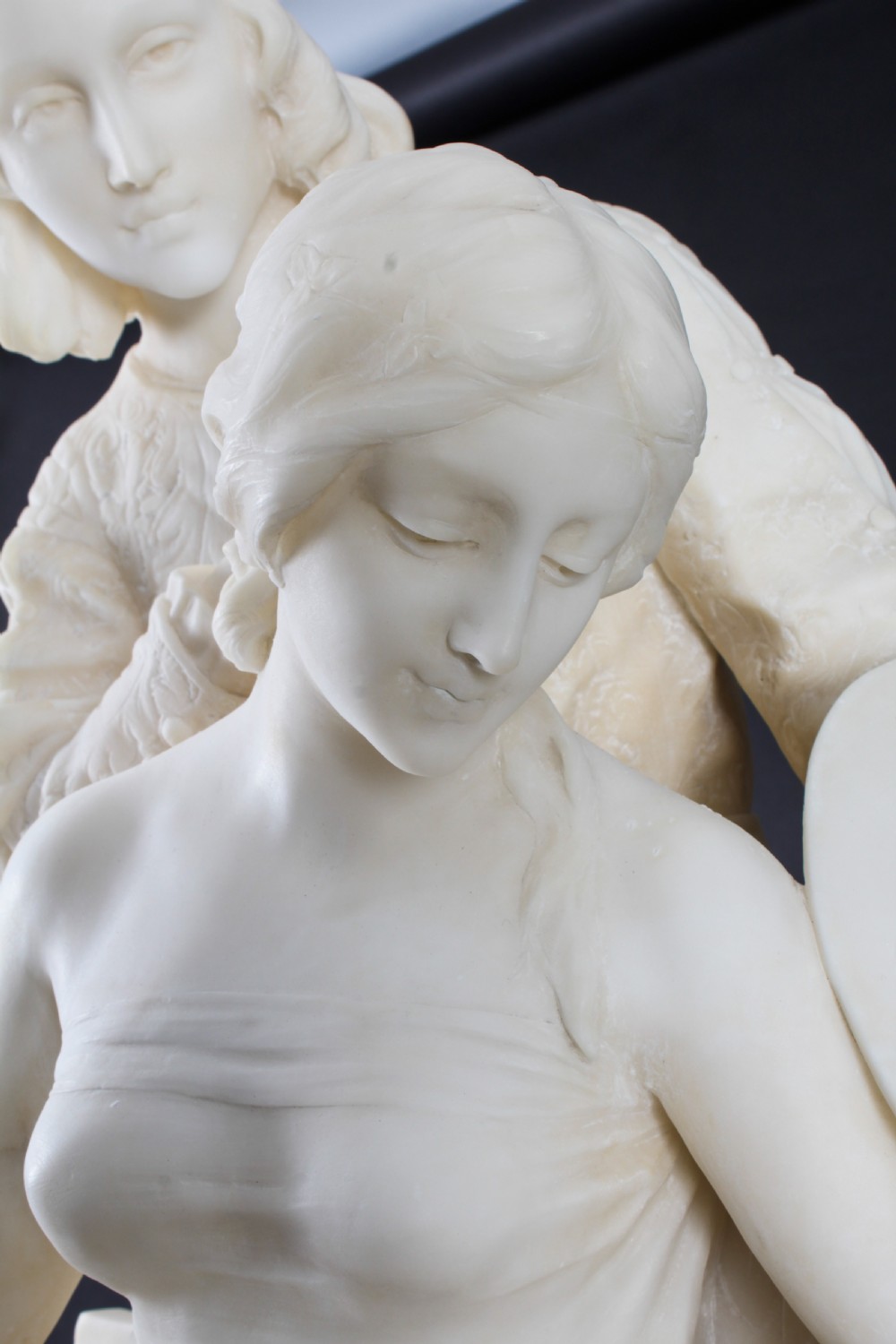 A 19th-century white carved alabaster sculpture depicting a seated female figure in drapery with a male figure standing behind her. View IV