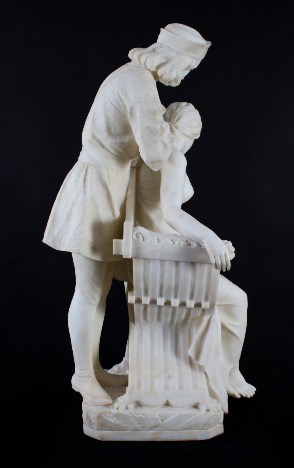 A 19th-century white carved alabaster sculpture depicting a seated female figure in drapery with a male figure standing behind her. View XXVI