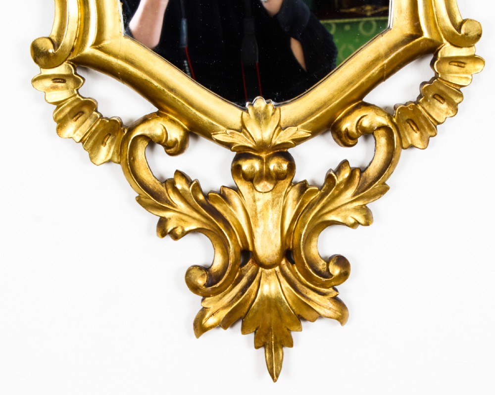 A matching pair of 19th-century Florentine Rococo carved giltwood wall mirror frames featuring intricate acanthus leaf cresting and scrollwork. View XVII