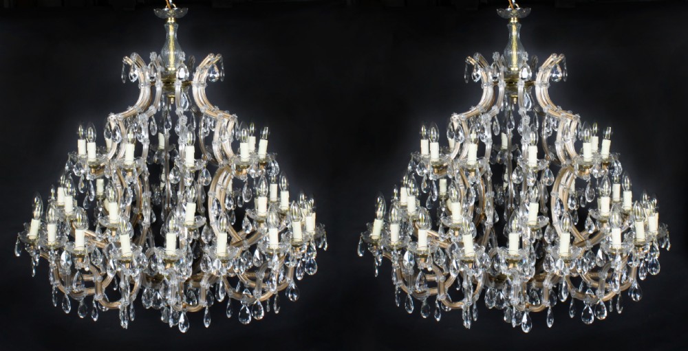 A pair of large multi-tiered crystal ballroom chandeliers featuring glass scroll arms and teardrop prisms. View XIV