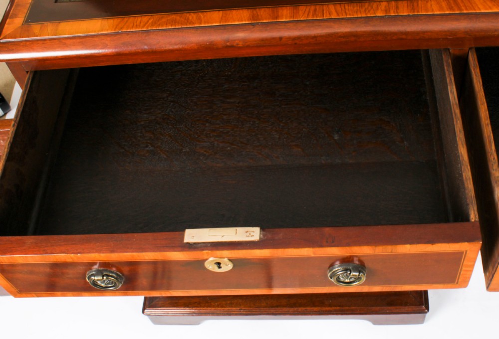 A Victorian flame mahogany partners pedestal desk featuring a green leather inset top and crossbanded drawer fronts with brass ring handles. View V