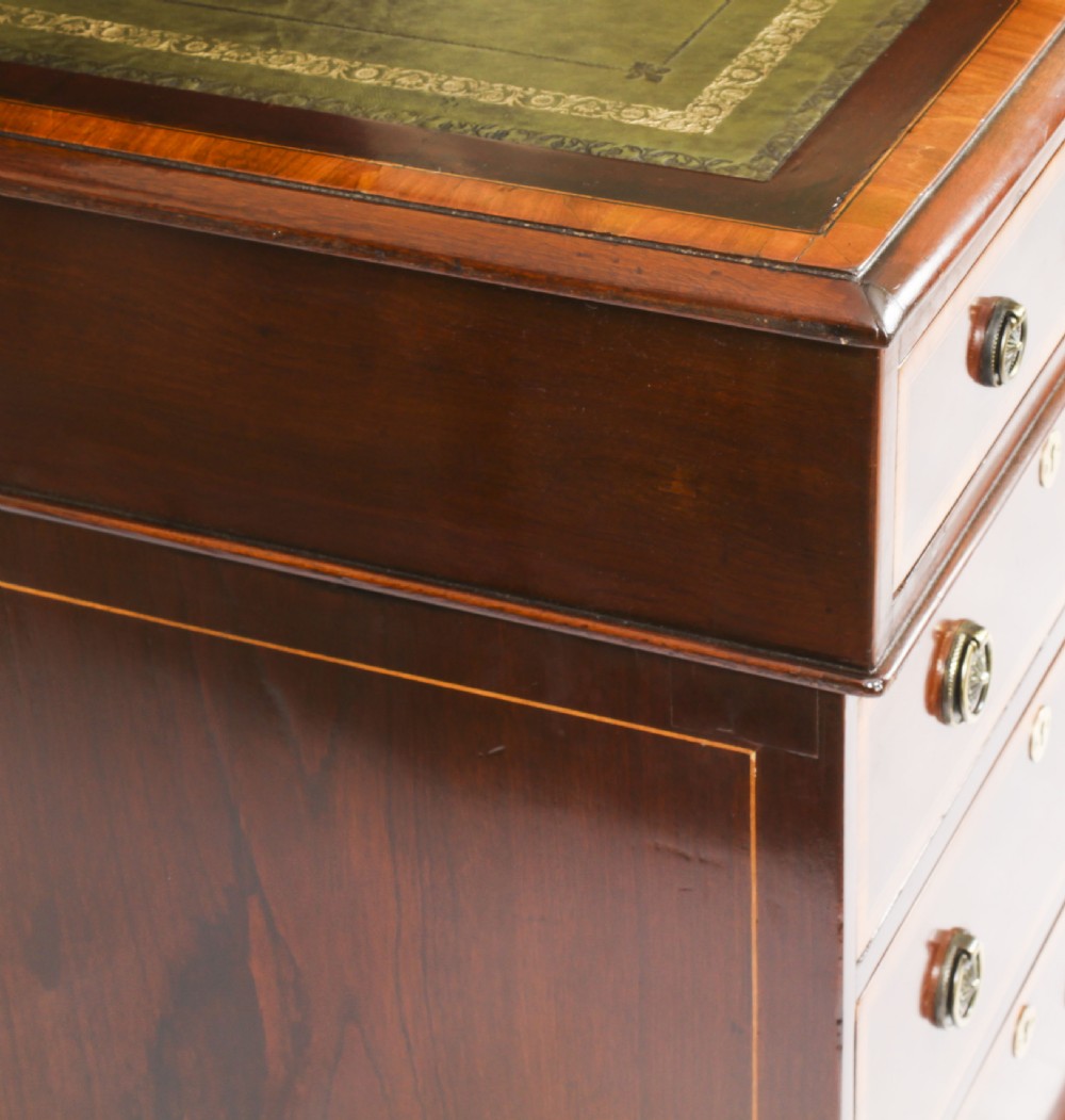 A Victorian flame mahogany partners pedestal desk featuring a green leather inset top and crossbanded drawer fronts with brass ring handles. View VIII