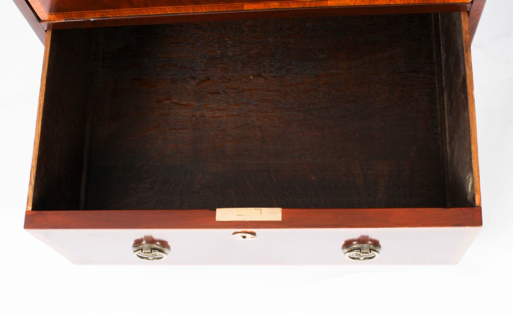 A Victorian flame mahogany partners pedestal desk featuring a green leather inset top and crossbanded drawer fronts with brass ring handles. View XVII