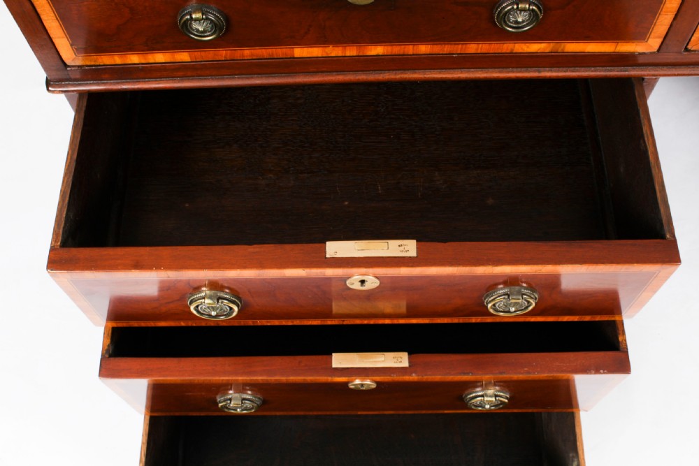 A Victorian flame mahogany partners pedestal desk featuring a green leather inset top and crossbanded drawer fronts with brass ring handles. View XX