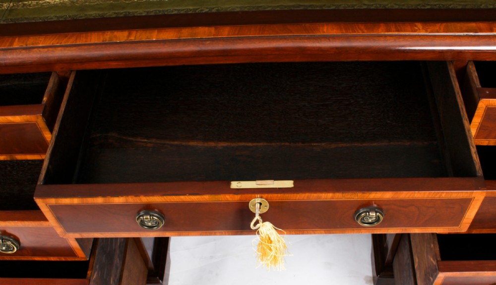 A Victorian flame mahogany partners pedestal desk featuring a green leather inset top and crossbanded drawer fronts with brass ring handles. View XXII