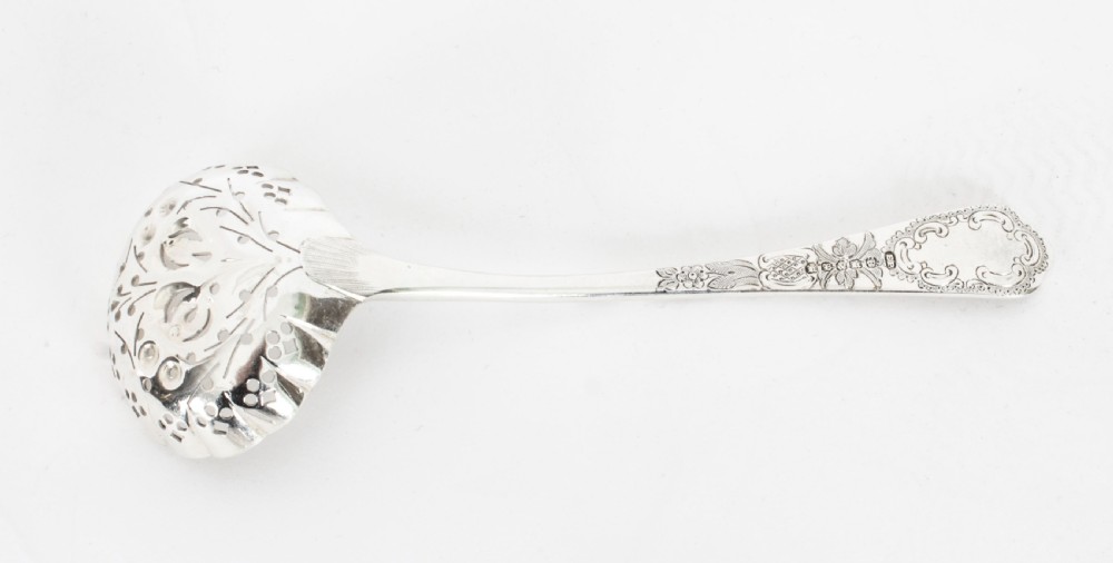 An open wooden case lined with deep purple velvet containing a silver-plated fruit serving set with embossed spoons and nutcrackers. View XVII