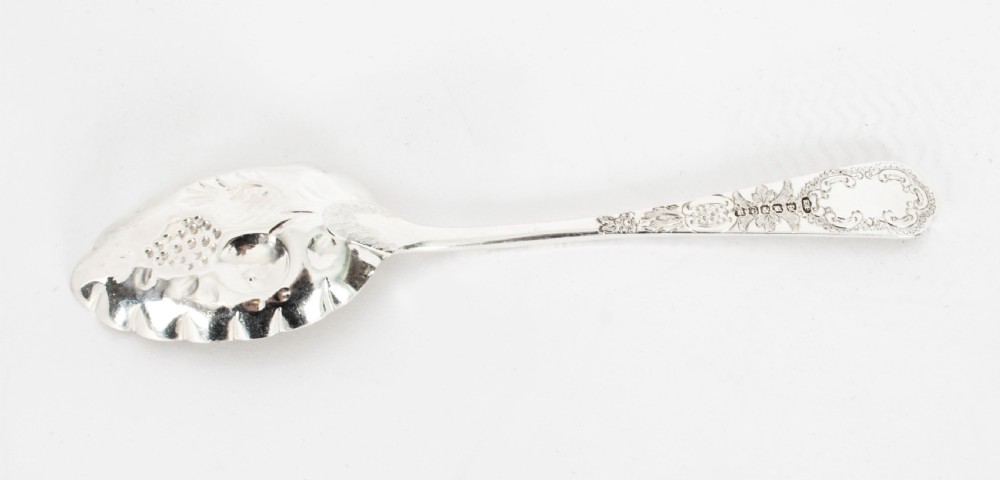 An open wooden case lined with deep purple velvet containing a silver-plated fruit serving set with embossed spoons and nutcrackers. View XXI