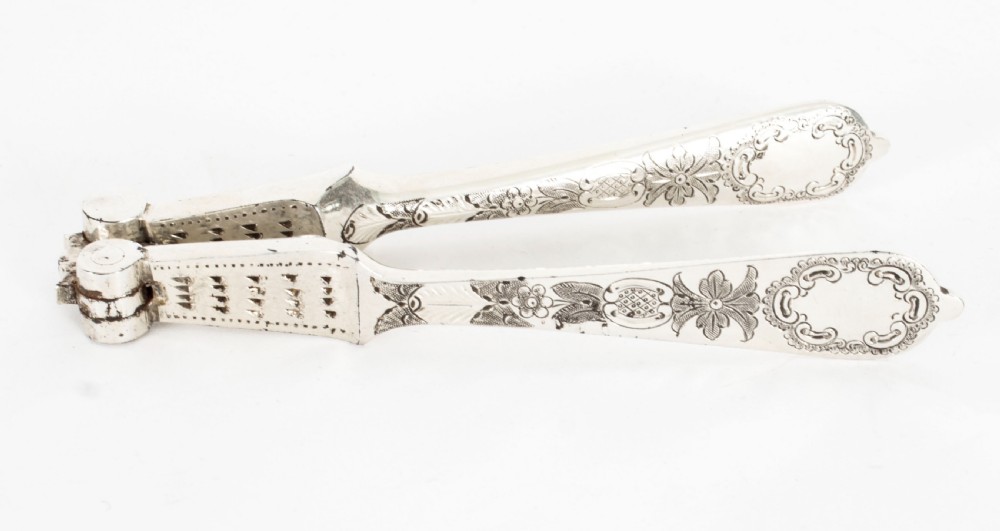 An open wooden case lined with deep purple velvet containing a silver-plated fruit serving set with embossed spoons and nutcrackers. View XXVII