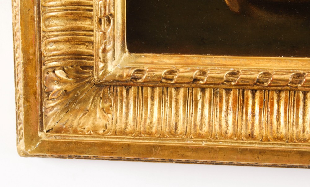 An oil painting depicting a seated young woman wearing a head turban and holding an illuminated scroll, encased in a fluted gold gilded frame. View IX
