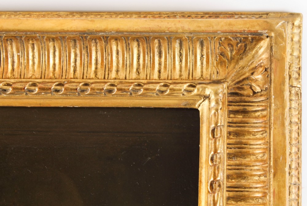 An oil painting depicting a seated young woman wearing a head turban and holding an illuminated scroll, encased in a fluted gold gilded frame. View XI