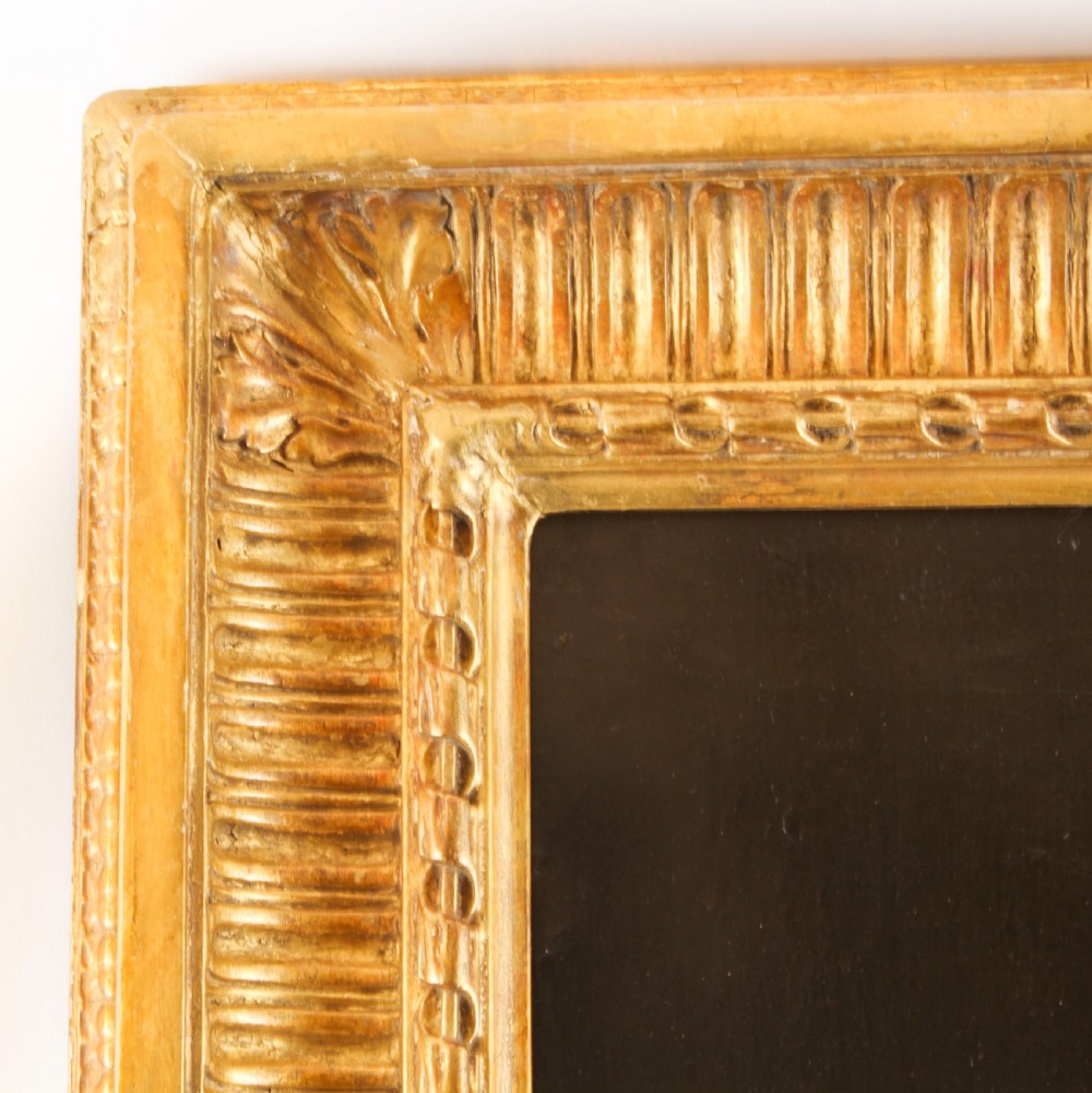 An oil painting depicting a seated young woman wearing a head turban and holding an illuminated scroll, encased in a fluted gold gilded frame. View XII