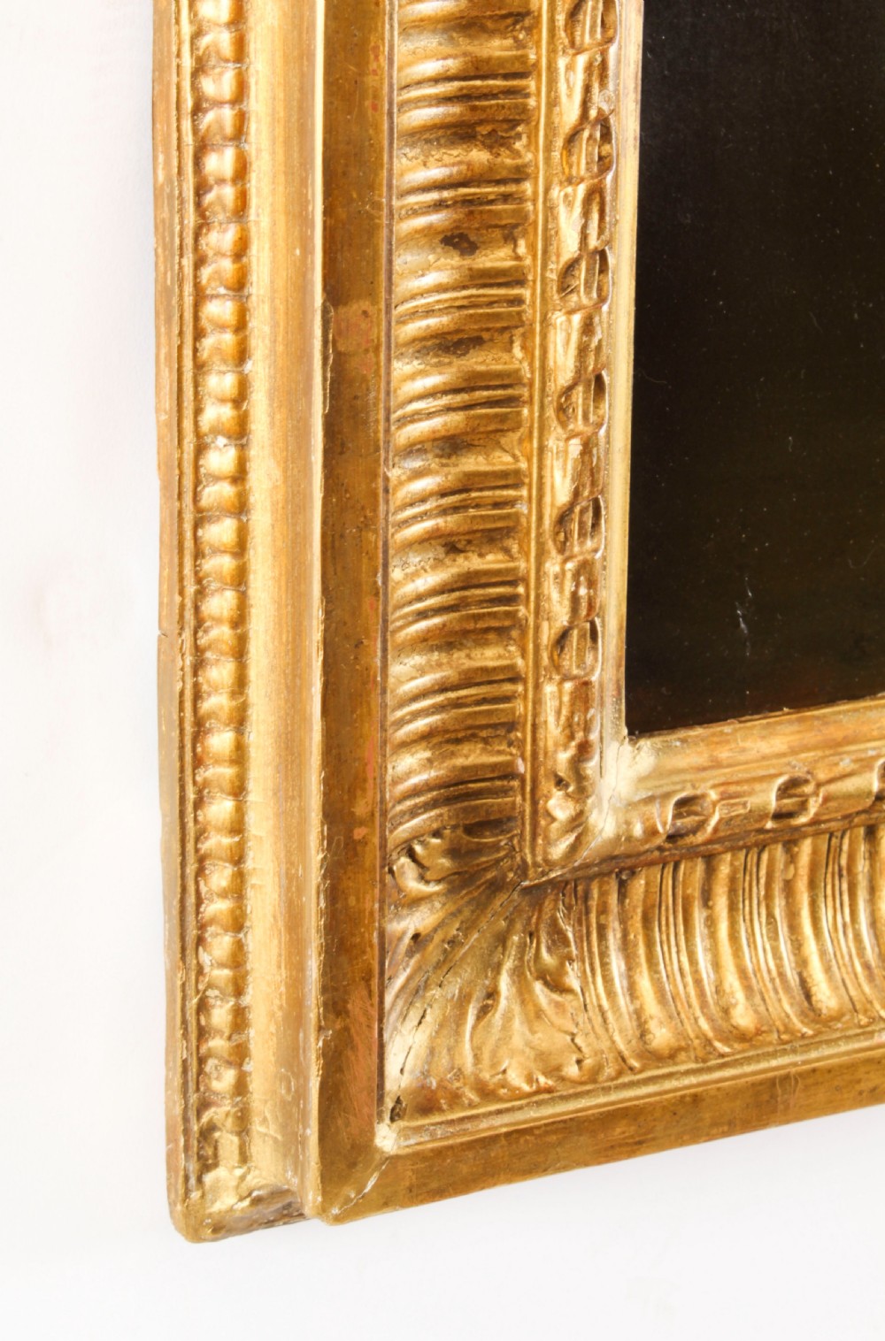 An oil painting depicting a seated young woman wearing a head turban and holding an illuminated scroll, encased in a fluted gold gilded frame. View XV