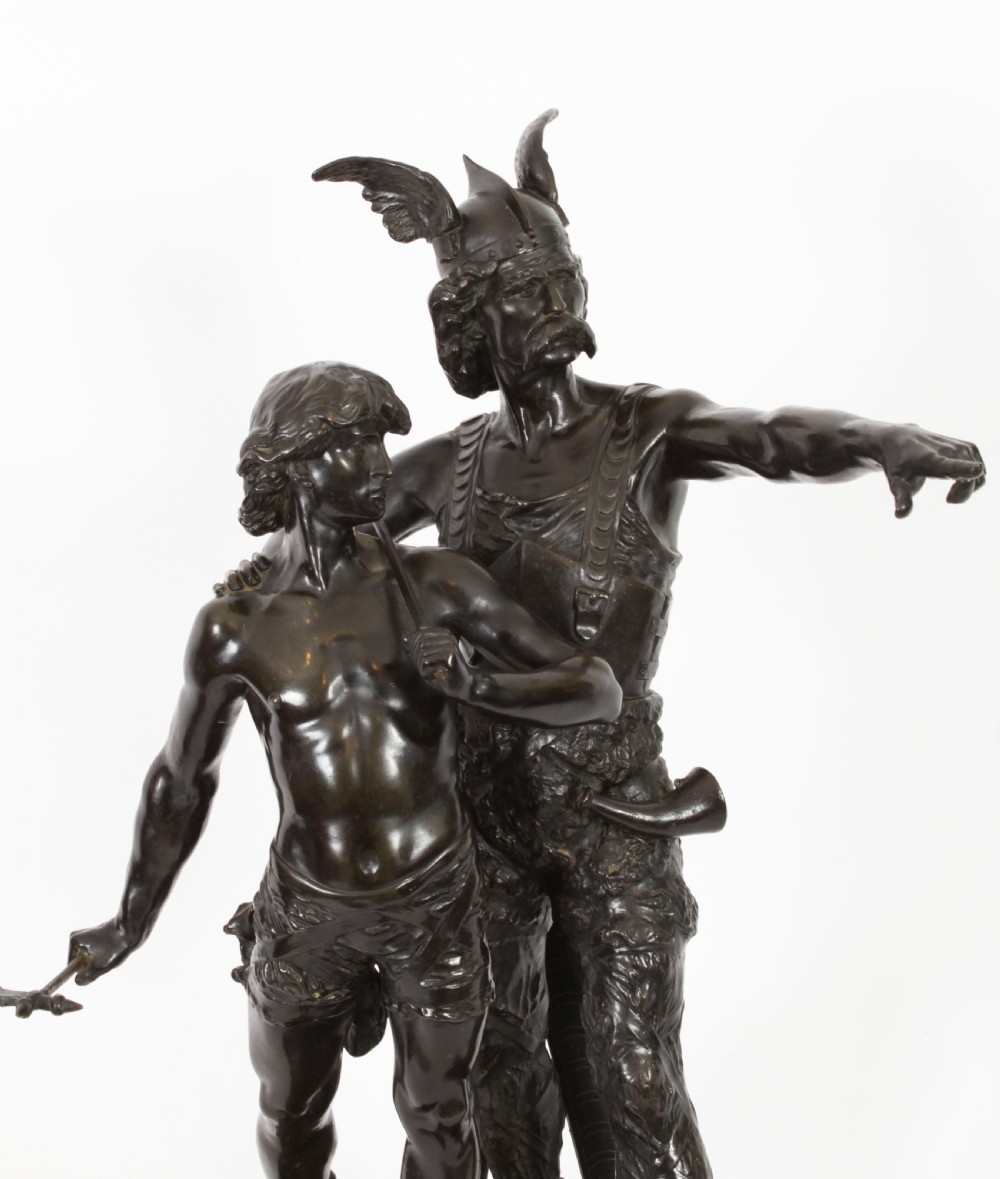 A 19th-century dark patinated bronze sculpture depicting a standing Gaulish warrior with a winged helmet pointing forward next to a young boy holding an axe on a rectangular base. View III