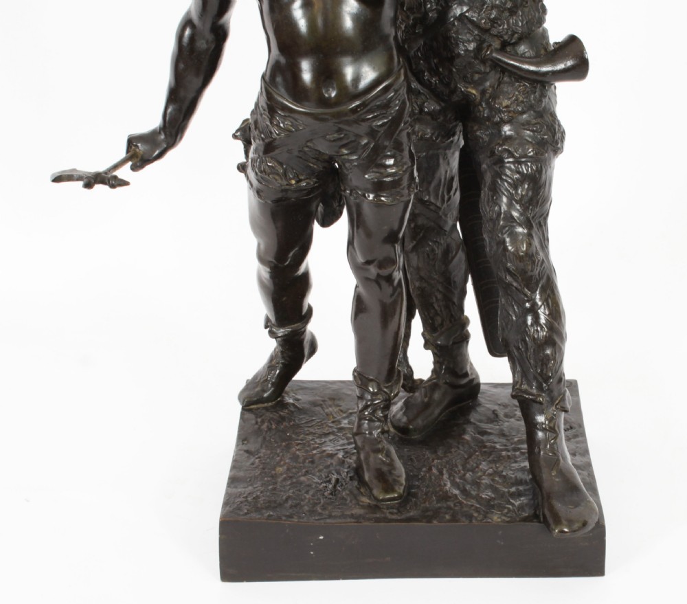 A 19th-century dark patinated bronze sculpture depicting a standing Gaulish warrior with a winged helmet pointing forward next to a young boy holding an axe on a rectangular base. View VI