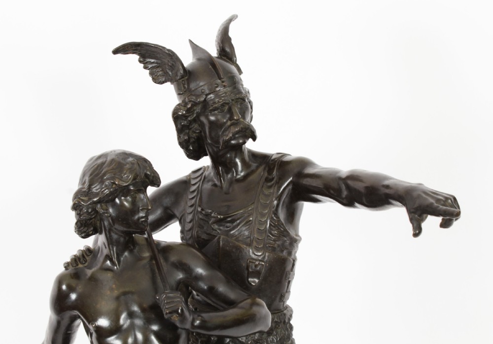 A 19th-century dark patinated bronze sculpture depicting a standing Gaulish warrior with a winged helmet pointing forward next to a young boy holding an axe on a rectangular base. View IX