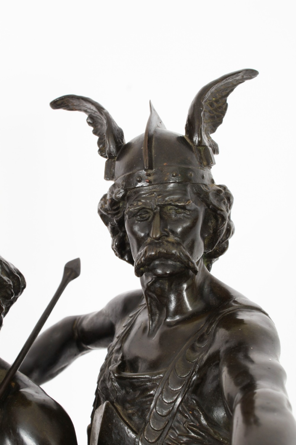 A 19th-century dark patinated bronze sculpture depicting a standing Gaulish warrior with a winged helmet pointing forward next to a young boy holding an axe on a rectangular base. View X