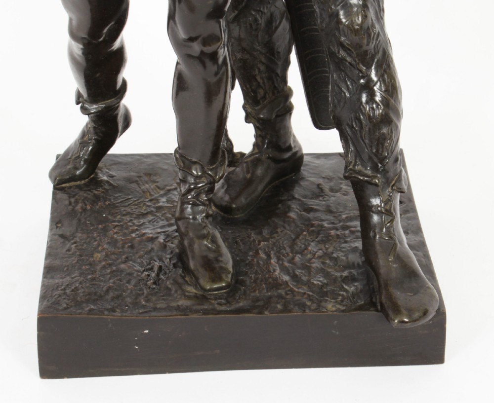 A 19th-century dark patinated bronze sculpture depicting a standing Gaulish warrior with a winged helmet pointing forward next to a young boy holding an axe on a rectangular base. View XII