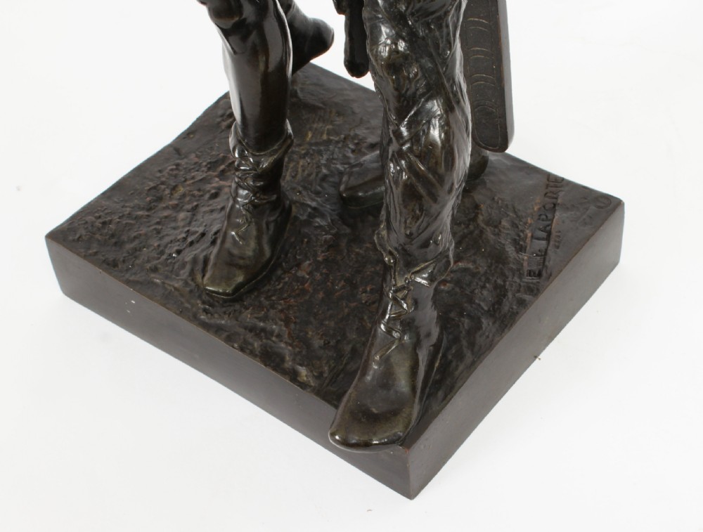 A 19th-century dark patinated bronze sculpture depicting a standing Gaulish warrior with a winged helmet pointing forward next to a young boy holding an axe on a rectangular base. View XIII