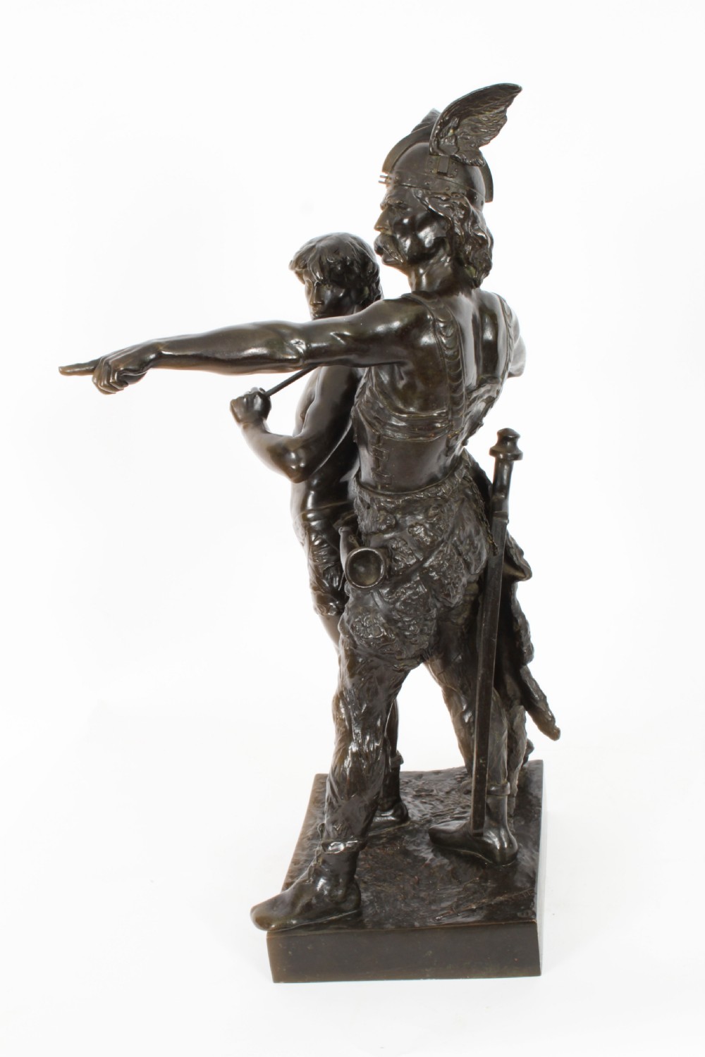 A 19th-century dark patinated bronze sculpture depicting a standing Gaulish warrior with a winged helmet pointing forward next to a young boy holding an axe on a rectangular base. View XIV