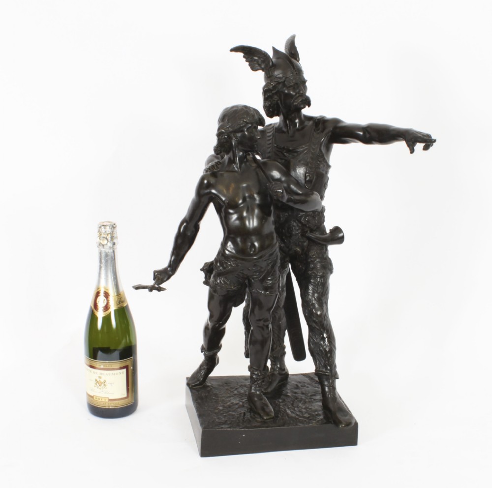 A 19th-century dark patinated bronze sculpture depicting a standing Gaulish warrior with a winged helmet pointing forward next to a young boy holding an axe on a rectangular base. View XX