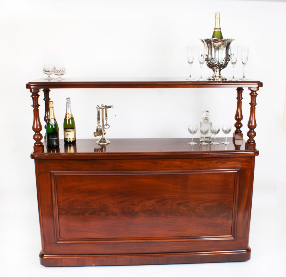 A Victorian flame mahogany dry bar featuring an elevated upper shelf supported by four turned balusters over a panelled lower counter. View III