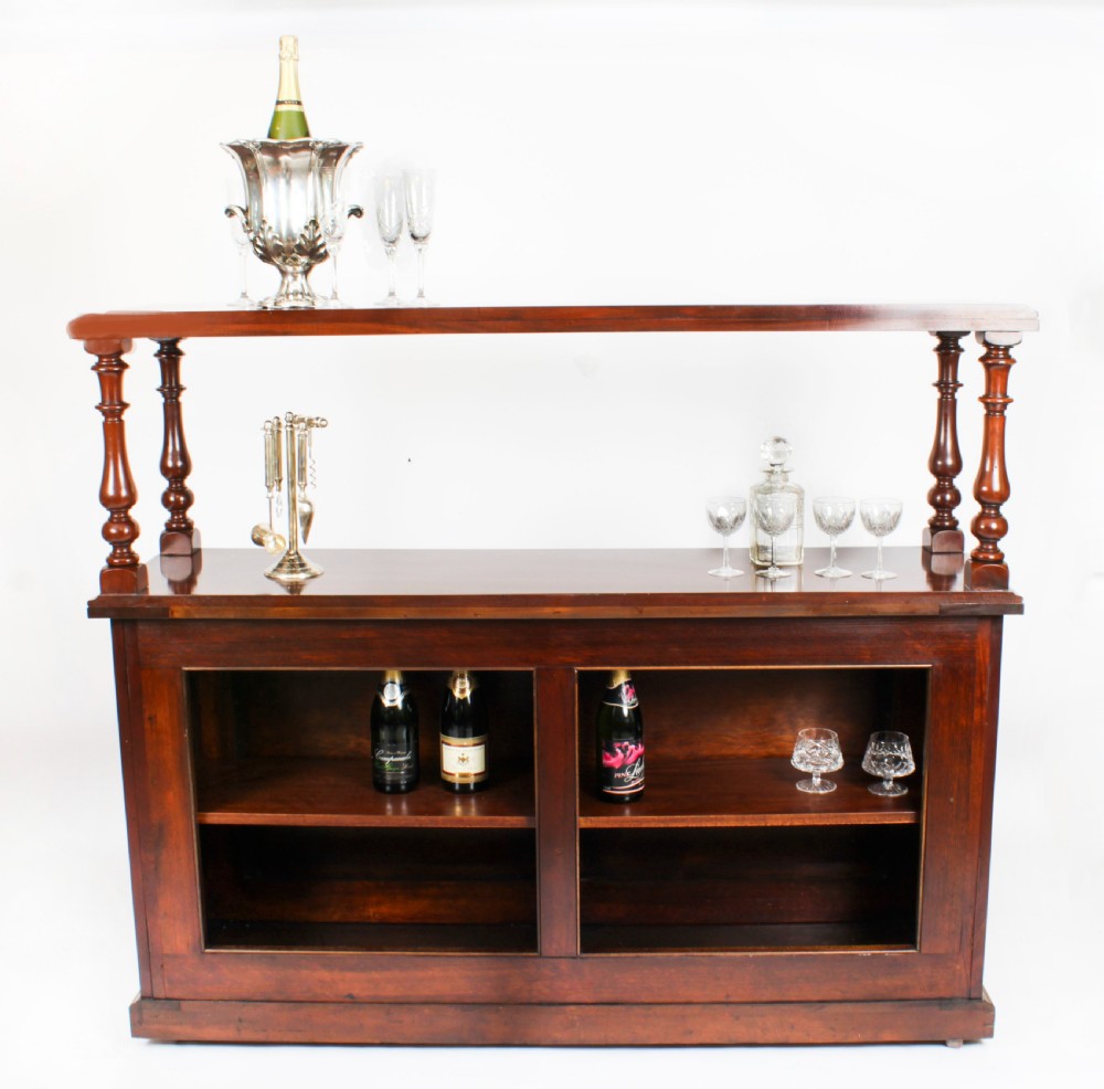 A Victorian flame mahogany dry bar featuring an elevated upper shelf supported by four turned balusters over a panelled lower counter. View IV