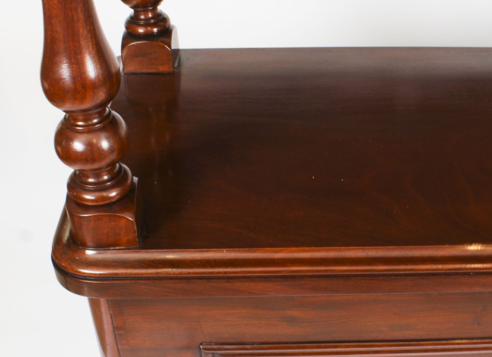 A Victorian flame mahogany dry bar featuring an elevated upper shelf supported by four turned balusters over a panelled lower counter. View X
