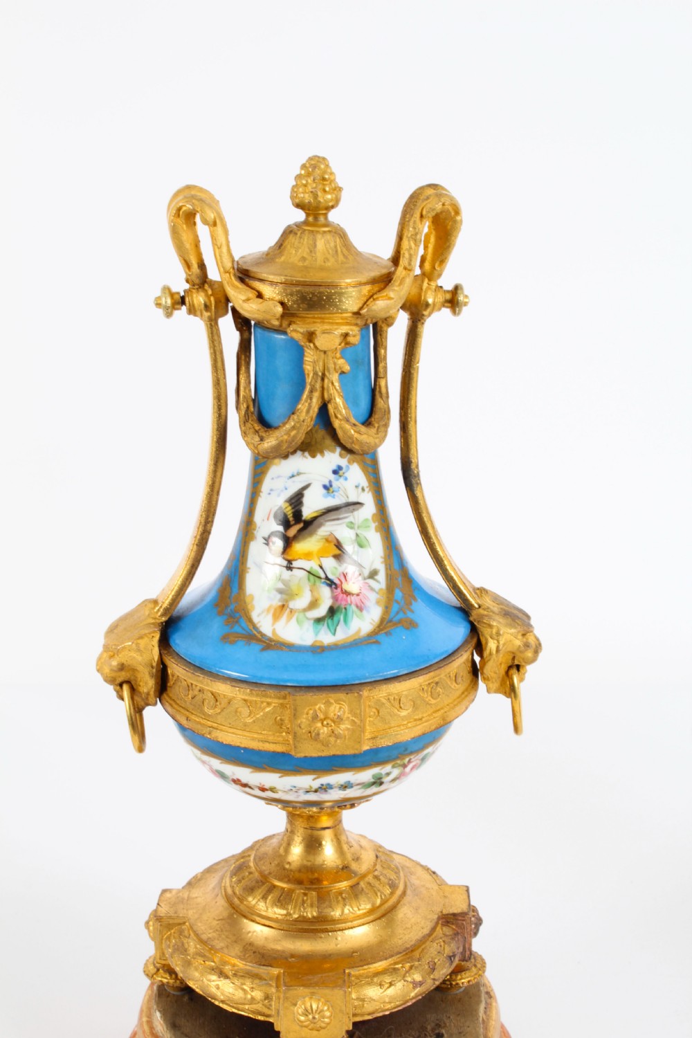 A pair of 19th-century French Sevres-style bleu celeste porcelain urns featuring hand-painted floral and bird reserves, supported by gilt metal mounts and pedestals. View III