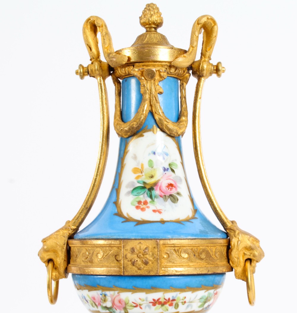 A pair of 19th-century French Sevres-style bleu celeste porcelain urns featuring hand-painted floral and bird reserves, supported by gilt metal mounts and pedestals. View XIV