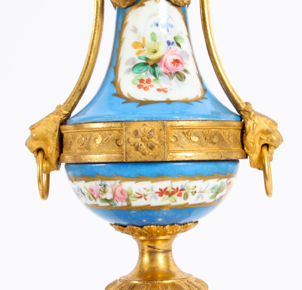A pair of 19th-century French Sevres-style bleu celeste porcelain urns featuring hand-painted floral and bird reserves, supported by gilt metal mounts and pedestals. View XV