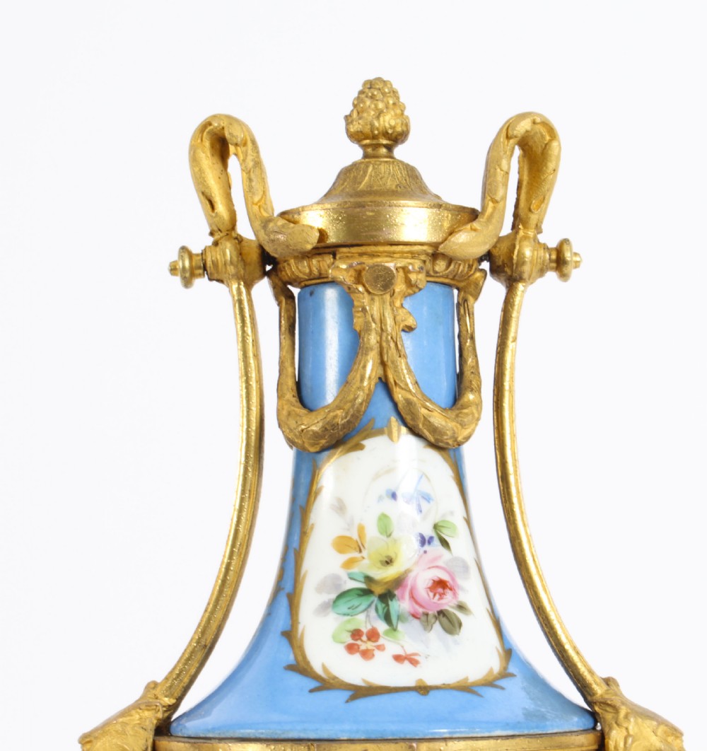 A pair of 19th-century French Sevres-style bleu celeste porcelain urns featuring hand-painted floral and bird reserves, supported by gilt metal mounts and pedestals. View XVI