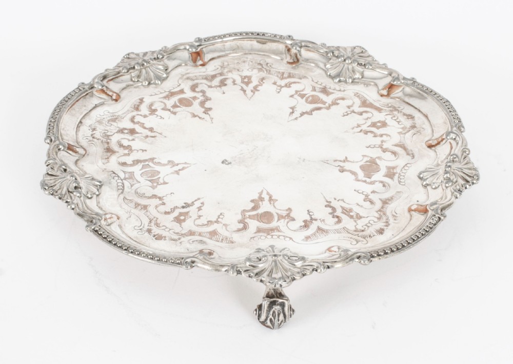 A Georgian Old Sheffield plate silver-plated salver featuring chased scroll engravings, shell motifs on a beaded rim, and resting on short feet. View III