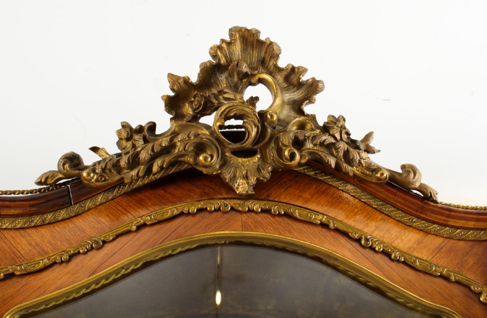 A nineteenth-century French Louis XV style bombee vitrine cabinet featuring curved glass panels, hand-painted Vernis Martin lower sections, and ornate gilt bronze mounts. View IV