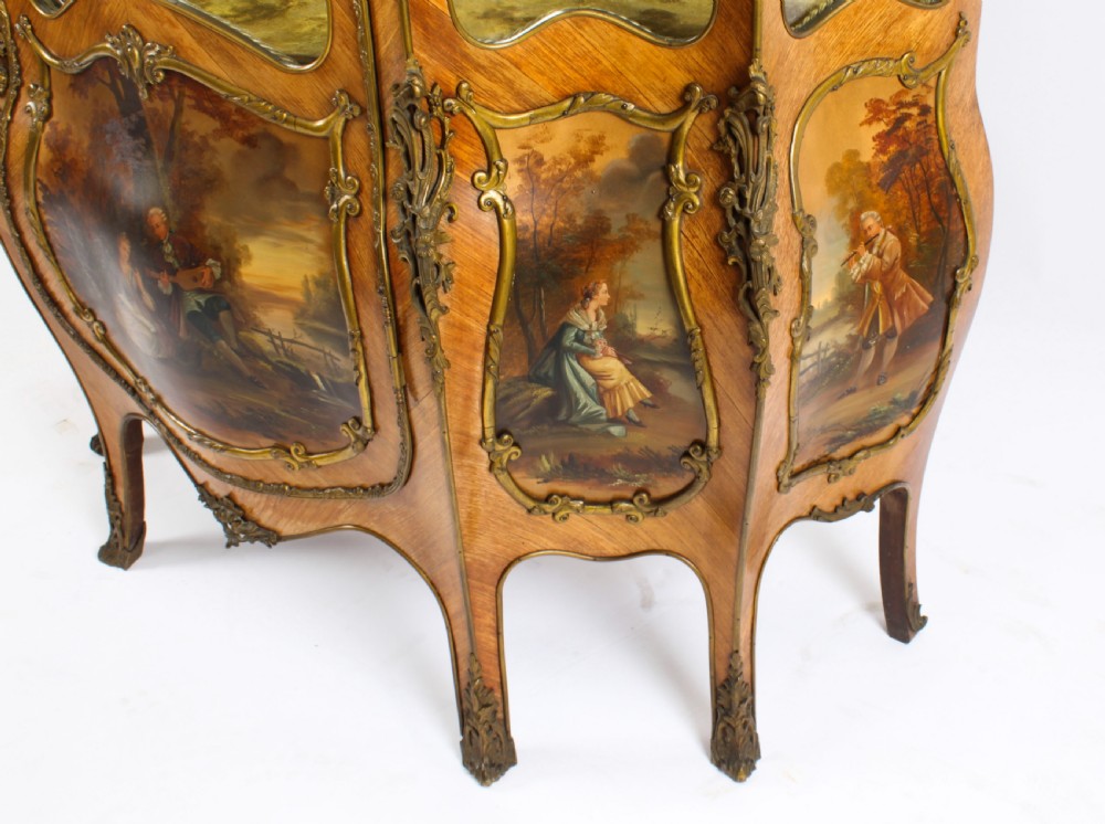 A nineteenth-century French Louis XV style bombee vitrine cabinet featuring curved glass panels, hand-painted Vernis Martin lower sections, and ornate gilt bronze mounts. View XX