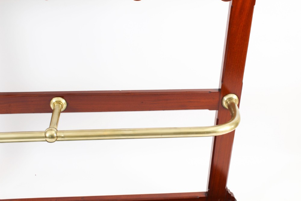 A Victorian mahogany hall stand featuring an arched fretwork top with wooden peg hooks, a brass umbrella bar, and a fitted drip pan base. View XII