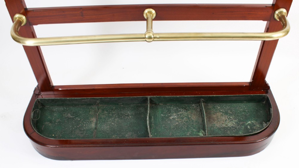 A Victorian mahogany hall stand featuring an arched fretwork top with wooden peg hooks, a brass umbrella bar, and a fitted drip pan base. View XIII