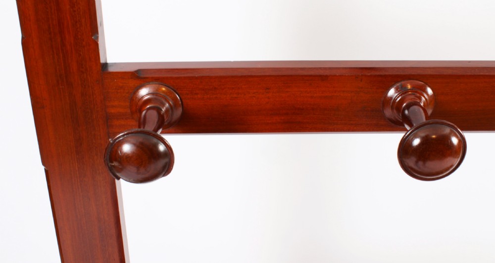 A Victorian mahogany hall stand featuring an arched fretwork top with wooden peg hooks, a brass umbrella bar, and a fitted drip pan base. View XIV