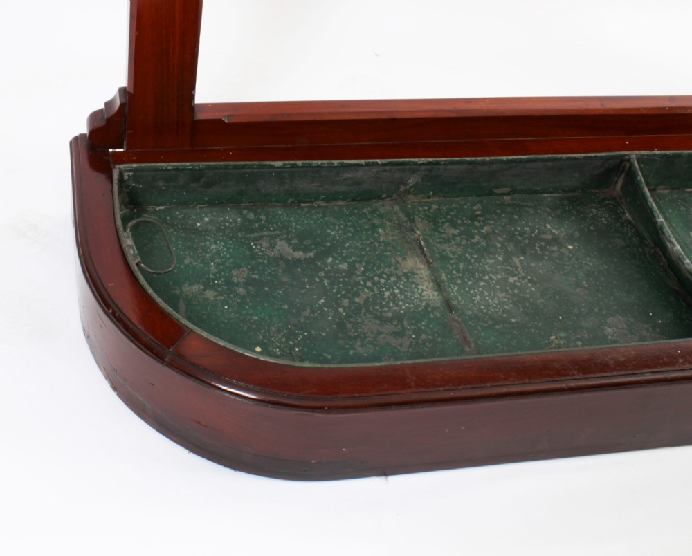 A Victorian mahogany hall stand featuring an arched fretwork top with wooden peg hooks, a brass umbrella bar, and a fitted drip pan base. View XV