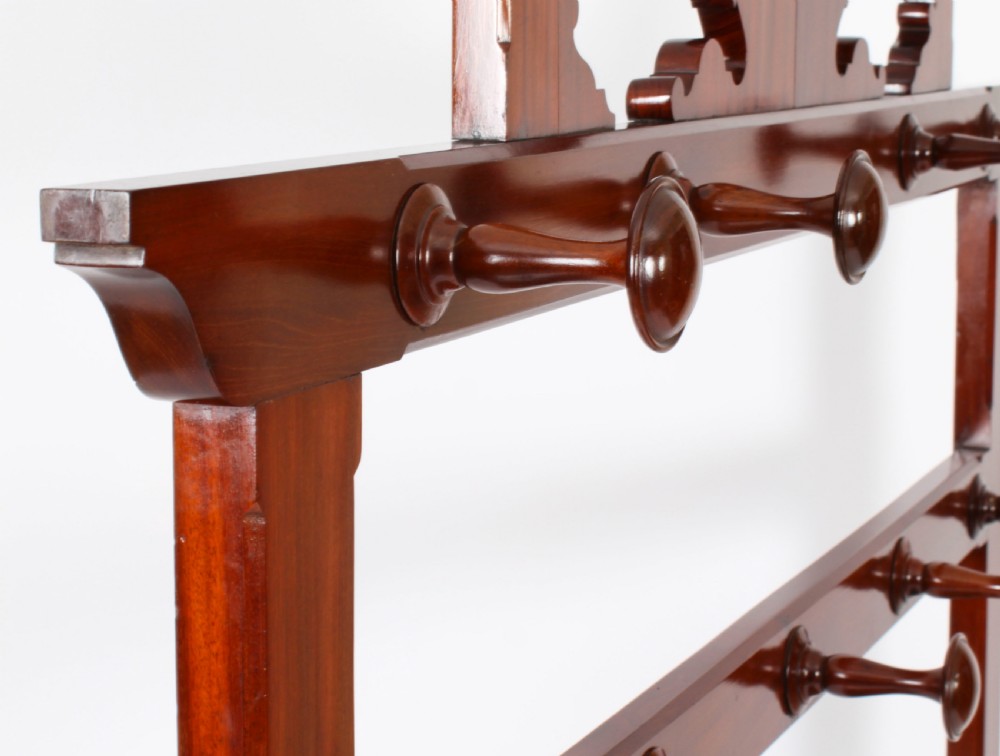 A Victorian mahogany hall stand featuring an arched fretwork top with wooden peg hooks, a brass umbrella bar, and a fitted drip pan base. View XVII