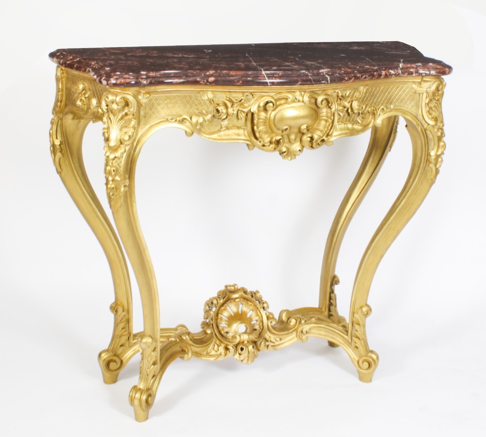 A 19th-century Louis Revival carved giltwood console table with cabriole legs and a dark red marble top.