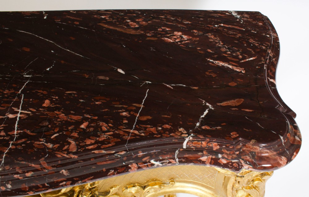 A 19th-century Louis Revival carved giltwood console table with cabriole legs and a dark red marble top. View VI