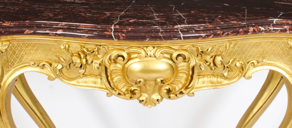 A 19th-century Louis Revival carved giltwood console table with cabriole legs and a dark red marble top. View VII