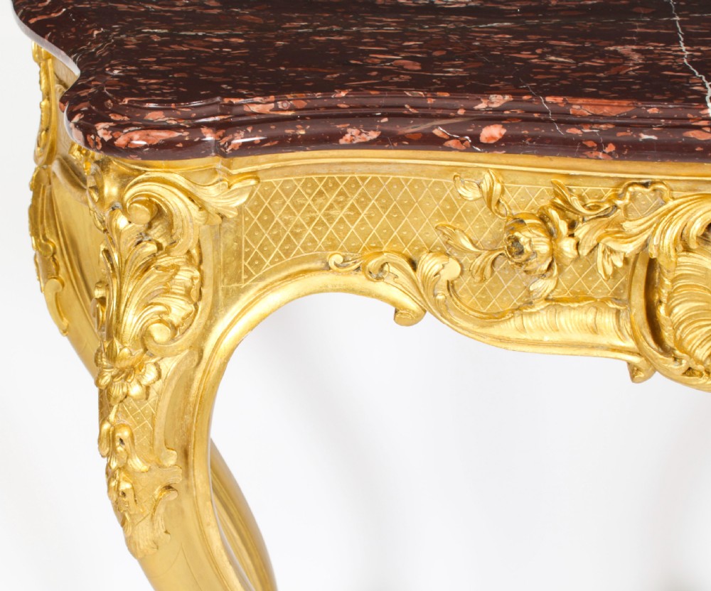 A 19th-century Louis Revival carved giltwood console table with cabriole legs and a dark red marble top. View IX