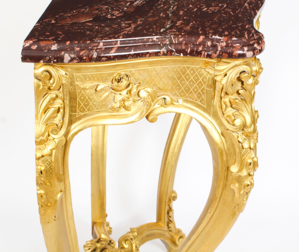 A 19th-century Louis Revival carved giltwood console table with cabriole legs and a dark red marble top. View XVI