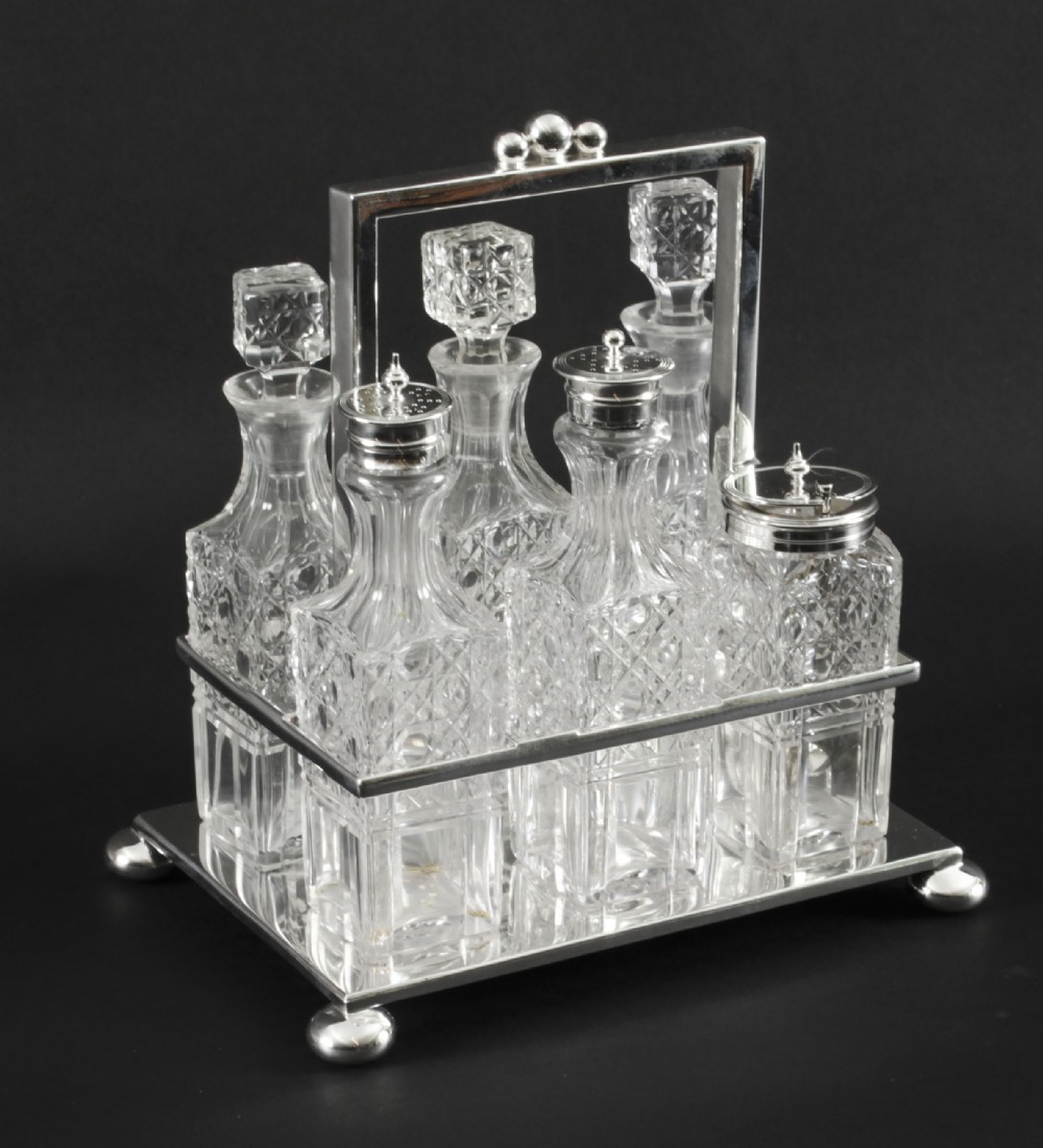 A Victorian silver-plated rectangular cruet stand holding six faceted cut-glass condiment bottles with metal tops and glass stoppers.