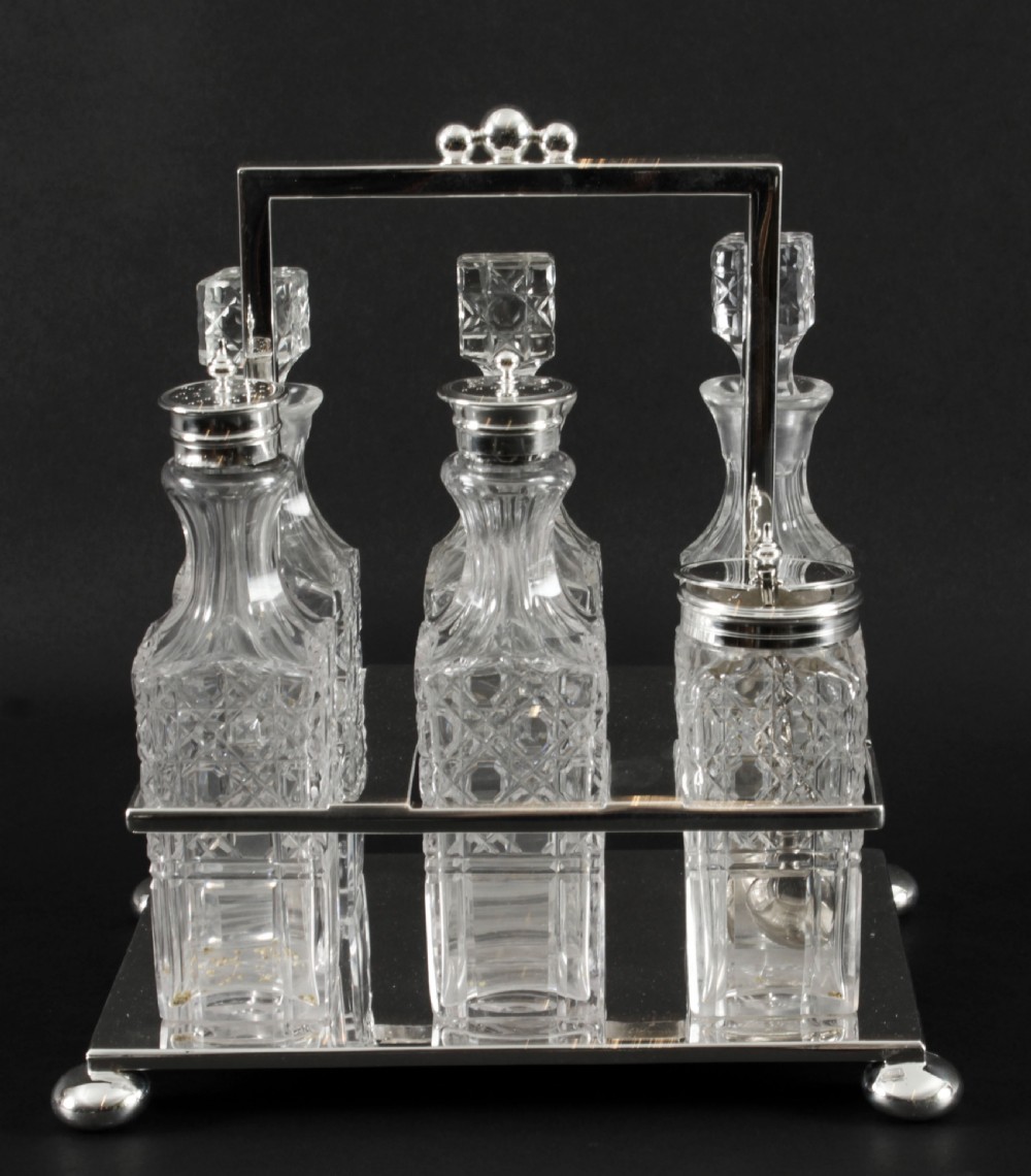 A Victorian silver-plated rectangular cruet stand holding six faceted cut-glass condiment bottles with metal tops and glass stoppers. View II