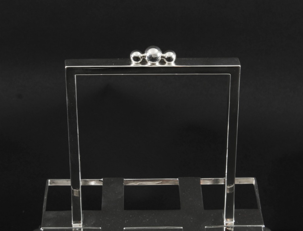 A Victorian silver-plated rectangular cruet stand holding six faceted cut-glass condiment bottles with metal tops and glass stoppers. View XXIV
