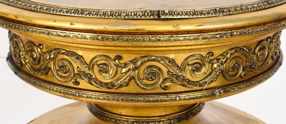 A 19th-century French giltwood cylindrical pedestal display cabinet featuring curved glass panels, an interior shelf, and carved guilloche mouldings. View V