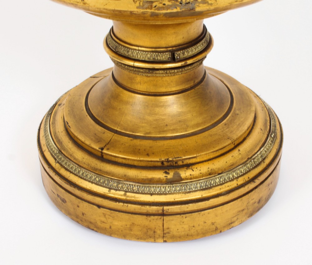 A 19th-century French giltwood cylindrical pedestal display cabinet featuring curved glass panels, an interior shelf, and carved guilloche mouldings. View XI